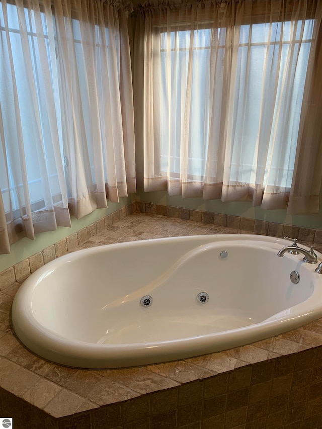 bathroom with plenty of natural light and tiled bath