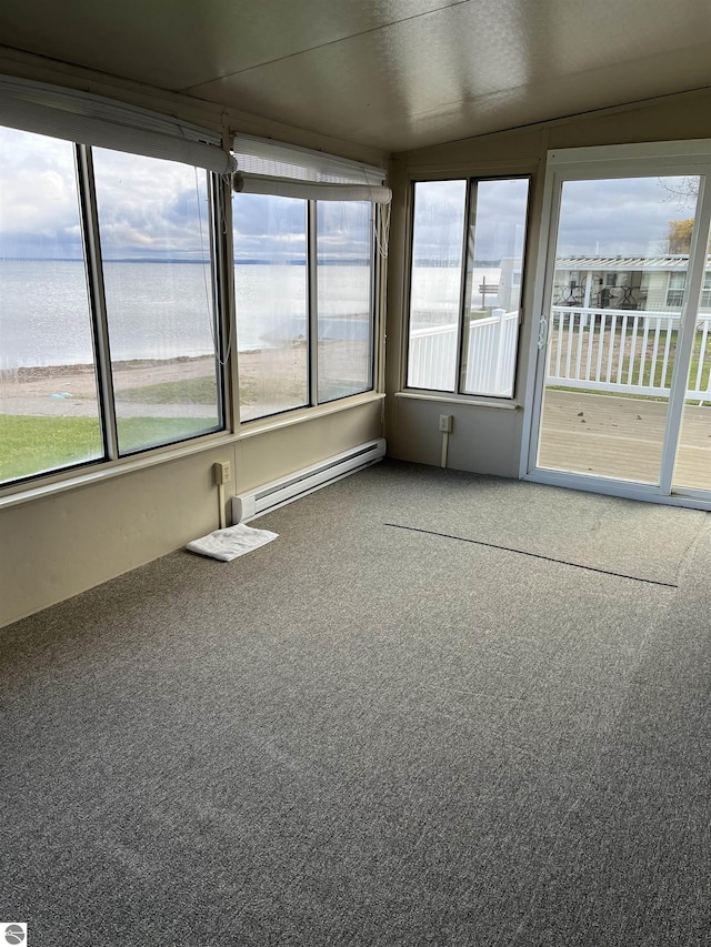 unfurnished sunroom with a water view, baseboard heating, and a wealth of natural light