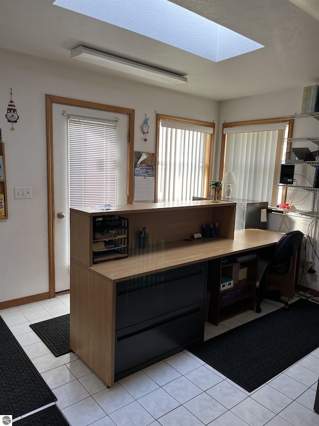 kitchen featuring a skylight and light tile patterned floors