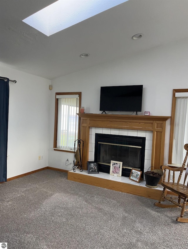 unfurnished living room with lofted ceiling with skylight, a fireplace, and carpet floors