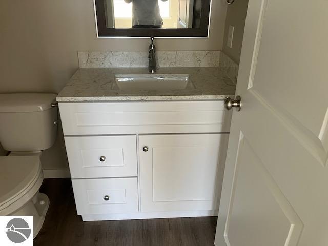 bathroom featuring hardwood / wood-style flooring, vanity, and toilet