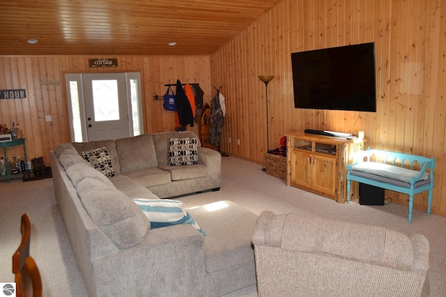 living room with wood ceiling, vaulted ceiling, carpet, and wooden walls