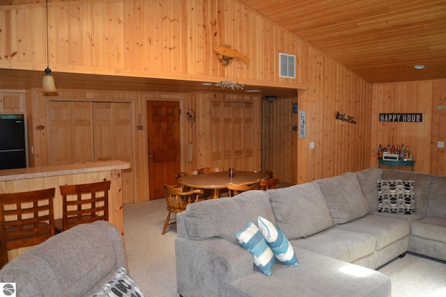 living room with wood walls, carpet, and wood ceiling