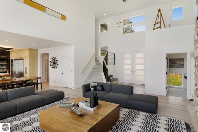 living room with a high ceiling and light wood-type flooring