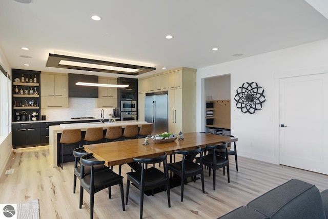 dining area featuring sink and light hardwood / wood-style flooring