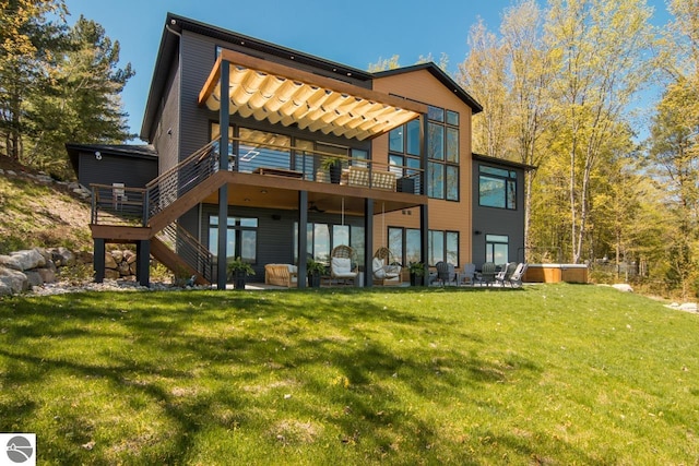 rear view of property with a patio area, a wooden deck, and a lawn