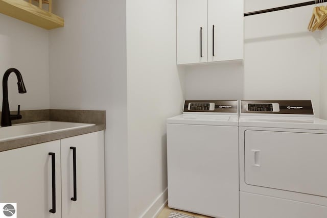 laundry room with sink, cabinets, and washing machine and clothes dryer