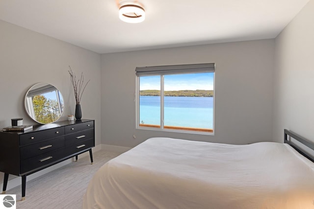 carpeted bedroom featuring a water view