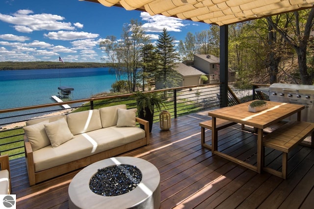 wooden deck with an outdoor living space with a fire pit and a water view