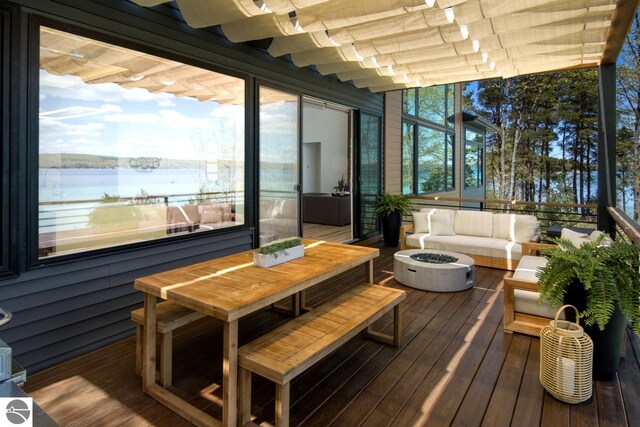 deck with a water view and an outdoor living space with a fire pit