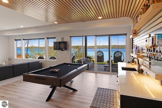 game room featuring sink, wood-type flooring, a water view, and billiards