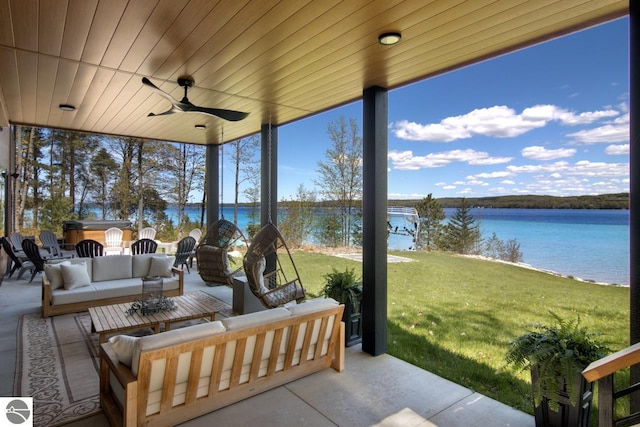 view of patio / terrace featuring an outdoor living space, ceiling fan, and a water view