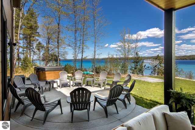 view of terrace featuring a hot tub and a water view