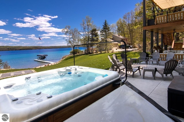 exterior space with a water view, an outdoor hot tub, and a balcony