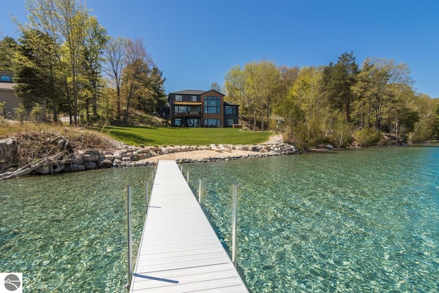 dock area with a lawn and a water view