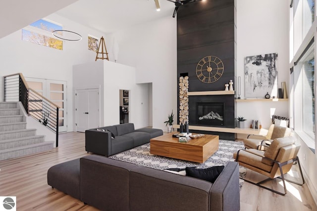 living room featuring light hardwood / wood-style flooring and a towering ceiling