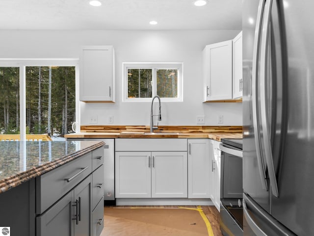 kitchen with light hardwood / wood-style floors, stainless steel appliances, white cabinetry, and sink