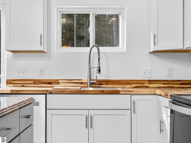 kitchen featuring white cabinetry and butcher block counters