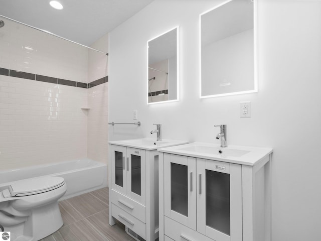 full bathroom featuring tiled shower / bath, toilet, tile flooring, and vanity