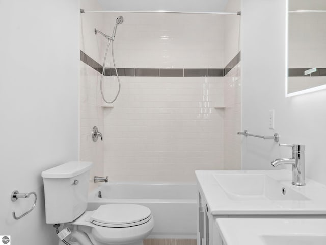 full bathroom with tiled shower / bath, vanity, and toilet