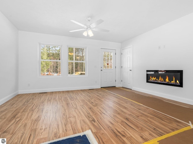 unfurnished living room featuring light hardwood / wood-style flooring and ceiling fan