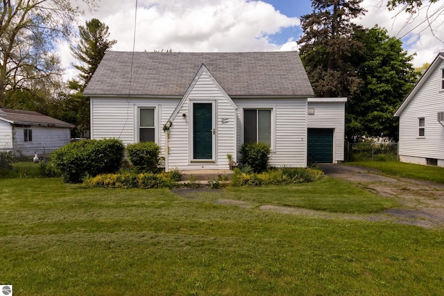 view of front of property featuring a garage, an outdoor structure, and a front lawn