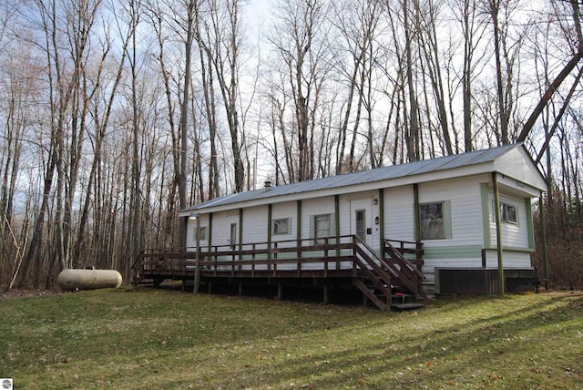 rear view of house with a deck and a yard