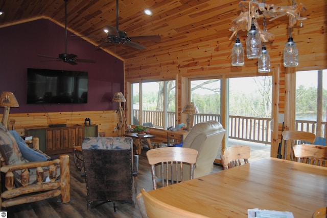 dining area with ceiling fan, high vaulted ceiling, hardwood / wood-style floors, wooden ceiling, and wood walls