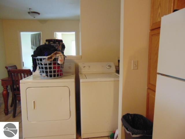 clothes washing area with independent washer and dryer and cabinets