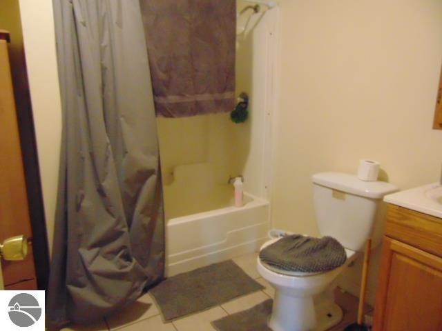 full bathroom with toilet, shower / tub combo, tile patterned floors, and vanity