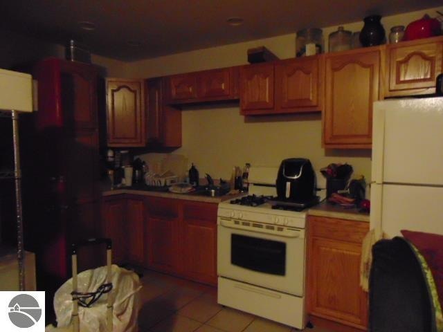 kitchen with white appliances and light tile patterned flooring