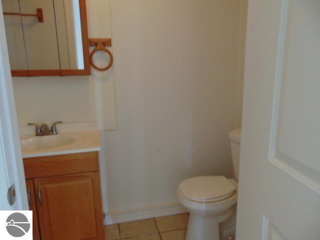 bathroom featuring toilet, vanity, and tile patterned floors