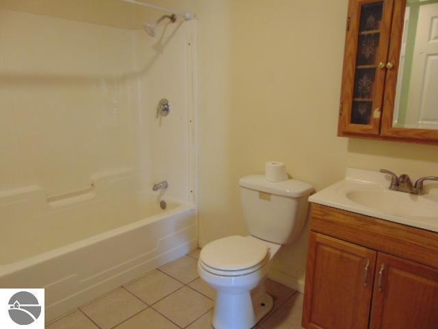 full bathroom with shower / bathtub combination, toilet, vanity, and tile patterned flooring