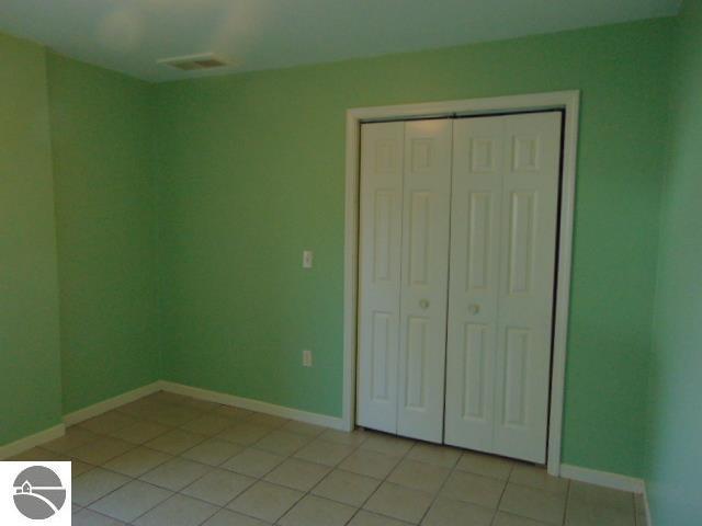 unfurnished bedroom with light tile patterned floors and a closet