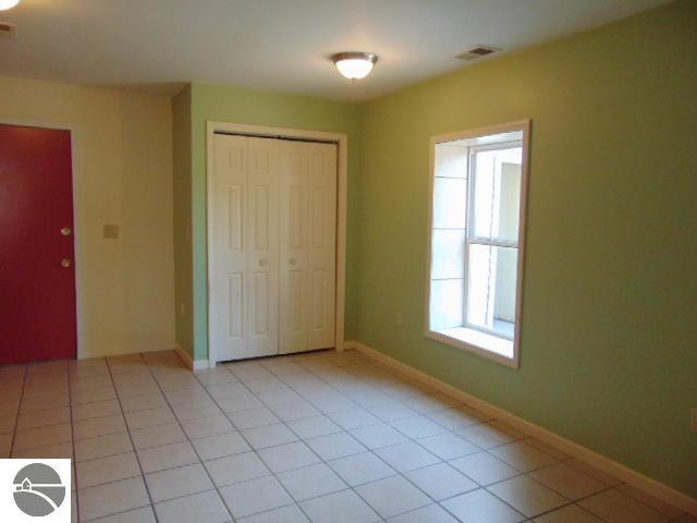 unfurnished bedroom featuring a closet and light tile patterned floors