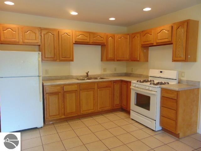 kitchen featuring light tile patterned floors, sink, and white appliances