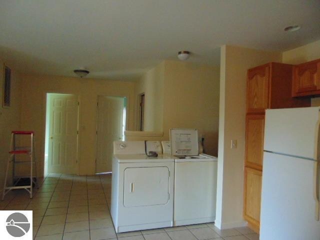 laundry room with light tile patterned floors and separate washer and dryer