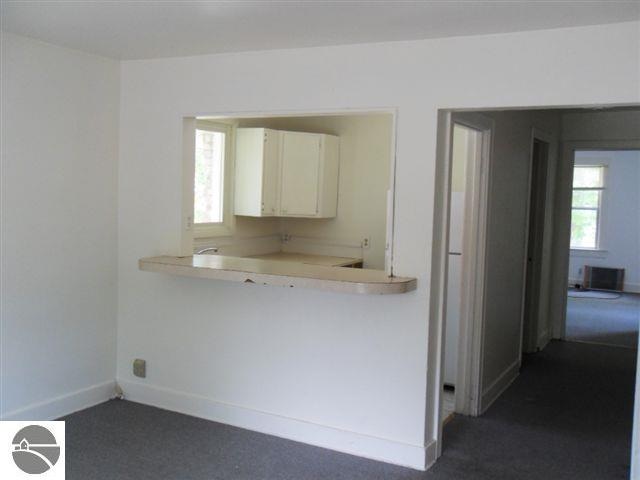 kitchen featuring dark carpet and white cabinetry