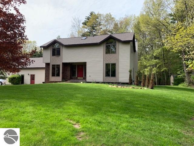 1165 E Lincoln St, East Tawas, MI 48730 - rear view of house featuring a lawn