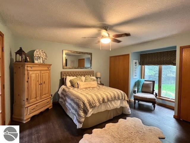 1165 E Lincoln St, East Tawas, MI 48730 - bedroom featuring a textured ceiling, ceiling fan, and dark hardwood / wood-style flooring