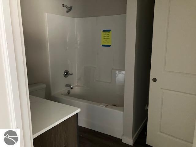 full bathroom featuring toilet, vanity, and washtub / shower combination