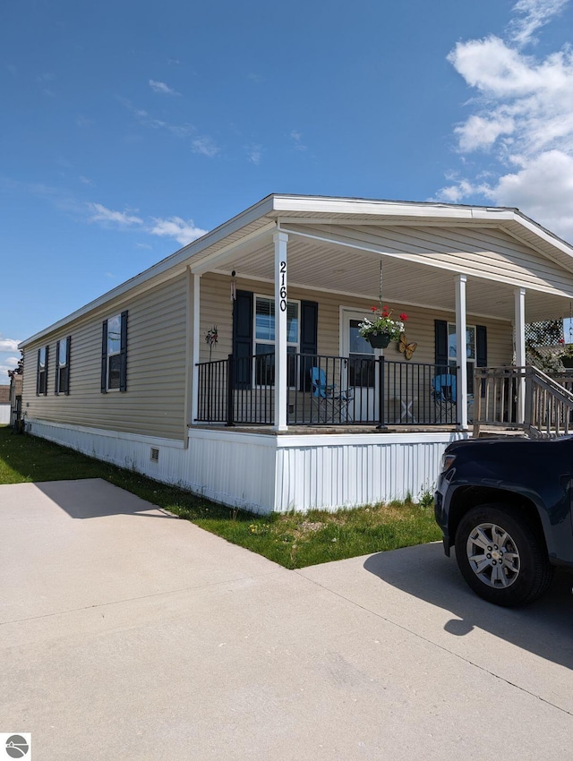 view of side of home featuring covered porch