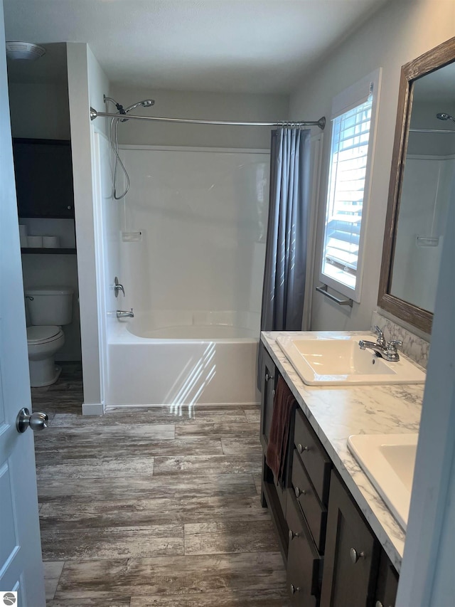 full bathroom with toilet, shower / bathtub combination with curtain, hardwood / wood-style floors, and double vanity