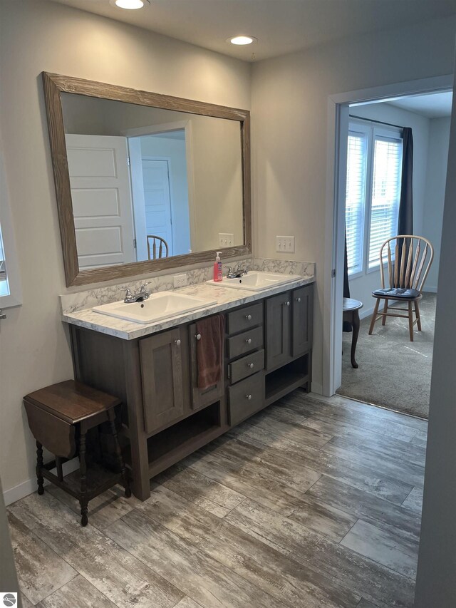 bathroom featuring hardwood / wood-style flooring and dual bowl vanity