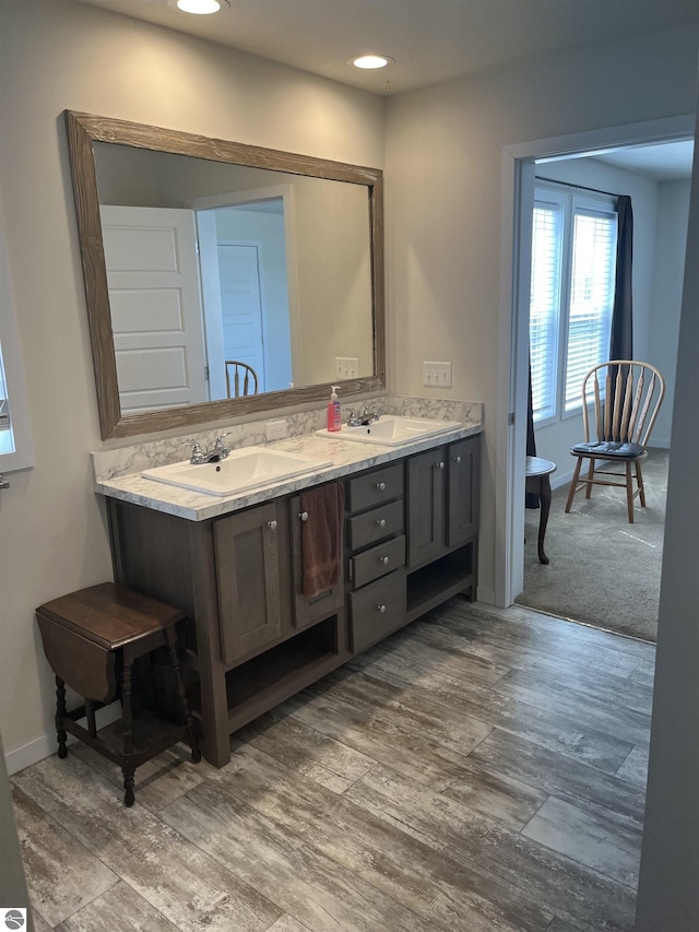 full bath featuring a sink, baseboards, and double vanity