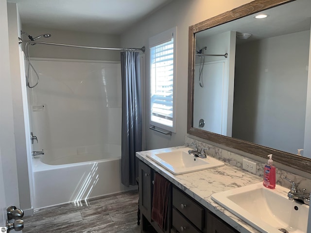 bathroom featuring double sink vanity, hardwood / wood-style floors, and shower / bath combination with curtain