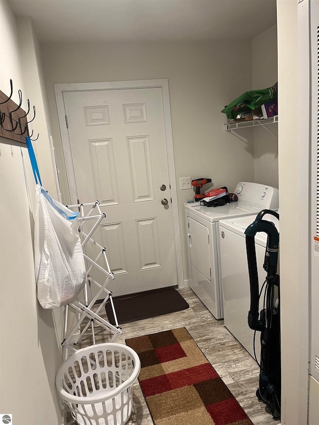 laundry area featuring independent washer and dryer and light hardwood / wood-style floors