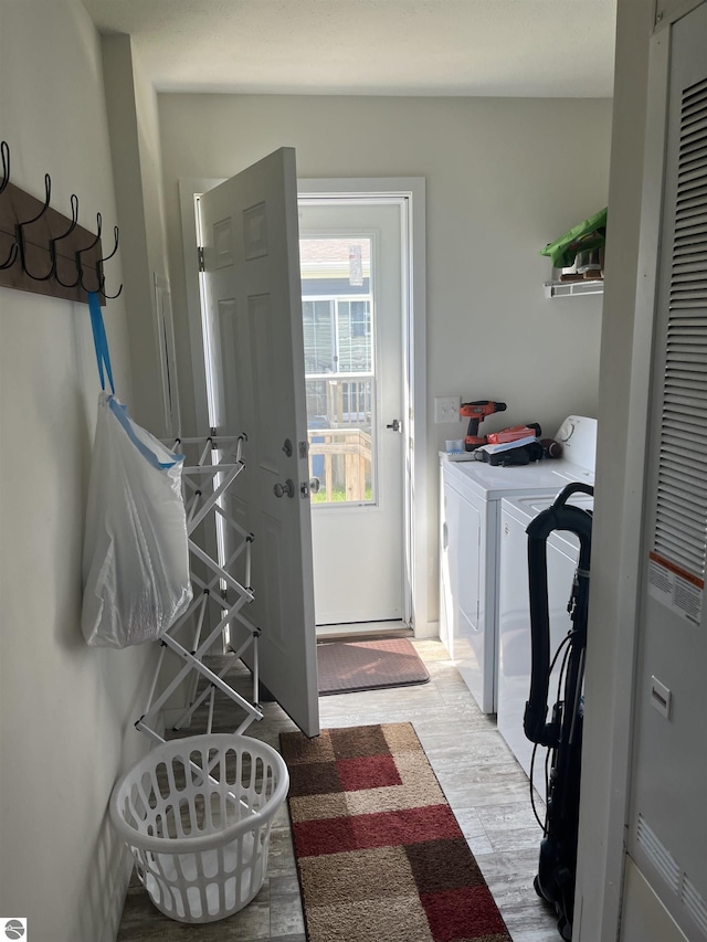 laundry room featuring laundry area, washing machine and clothes dryer, and light wood-style floors