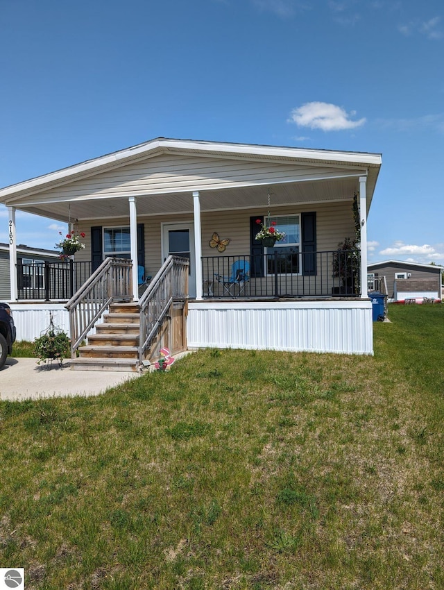 manufactured / mobile home featuring covered porch and a front yard