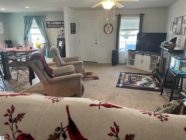 living room with light wood-type flooring, ceiling fan, and plenty of natural light